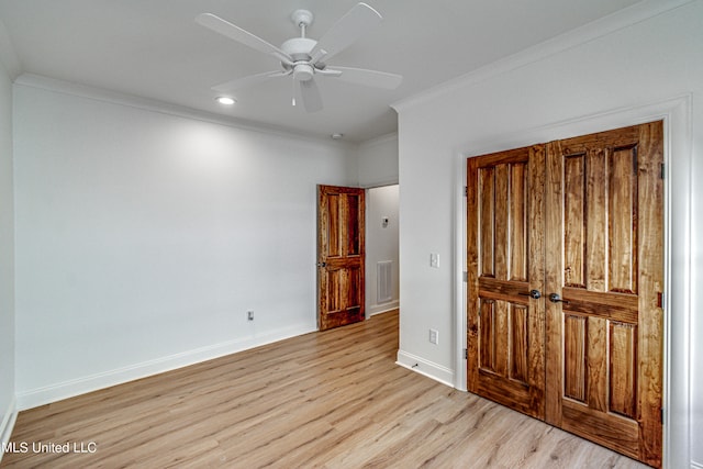 unfurnished bedroom featuring a closet, crown molding, light wood-type flooring, and ceiling fan