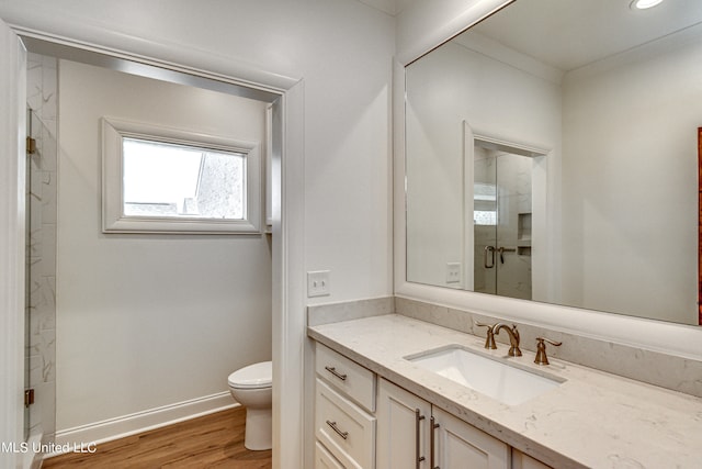 bathroom featuring toilet, walk in shower, vanity, and wood-type flooring