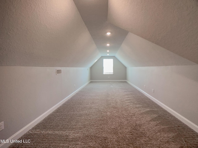 5807 Sylvester St, Ocean Springs, MS 39564 - additional living space featuring a textured ceiling, vaulted ceiling, carpet flooring, and baseboards