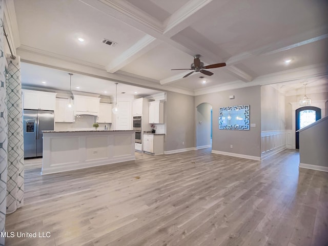 5807 Sylvester St, Ocean Springs, MS 39564 - unfurnished living room featuring a ceiling fan, light wood-style floors, beam ceiling, ornamental molding, and arched walkways