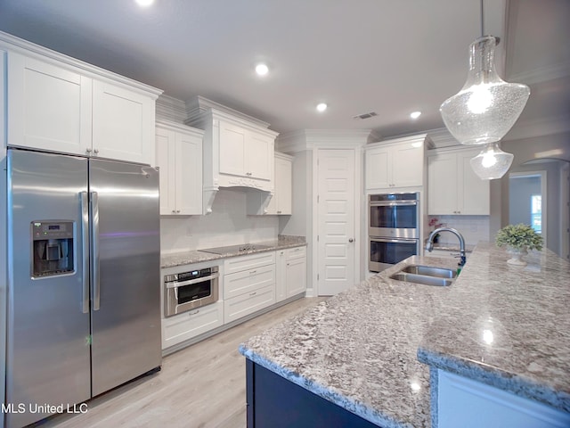 5807 Sylvester St, Ocean Springs, MS 39564 - kitchen with stainless steel appliances, a sink, white cabinetry, crown molding, and light stone counters
