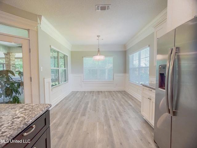 5807 Sylvester St, Ocean Springs, MS 39564 - unfurnished dining area with a wainscoted wall, light wood-type flooring, crown molding, and a decorative wall