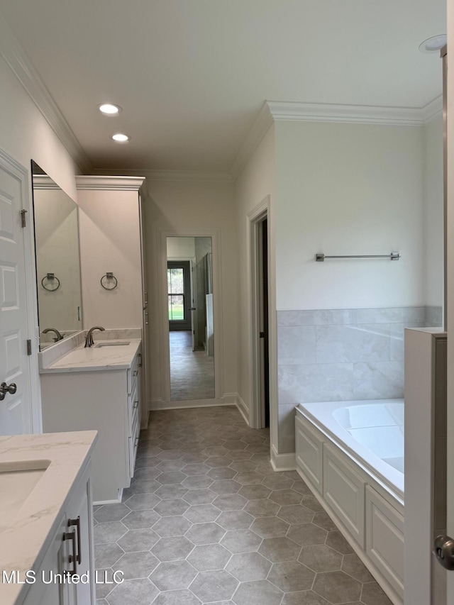 bathroom with a tub, tile patterned flooring, vanity, and ornamental molding