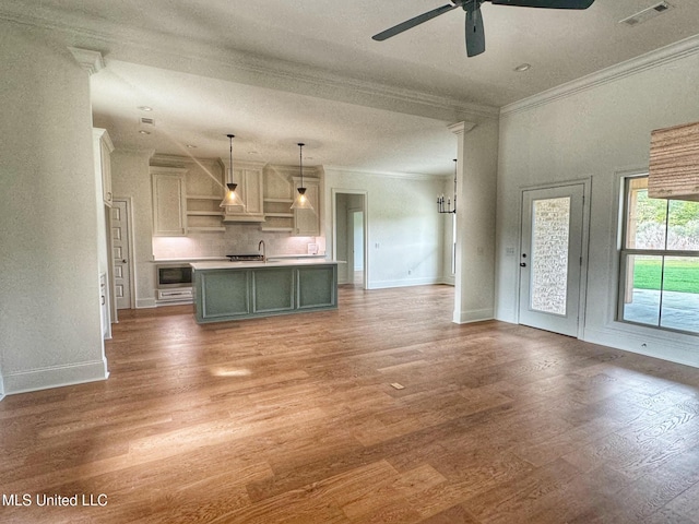 unfurnished living room featuring hardwood / wood-style flooring, ceiling fan, and crown molding