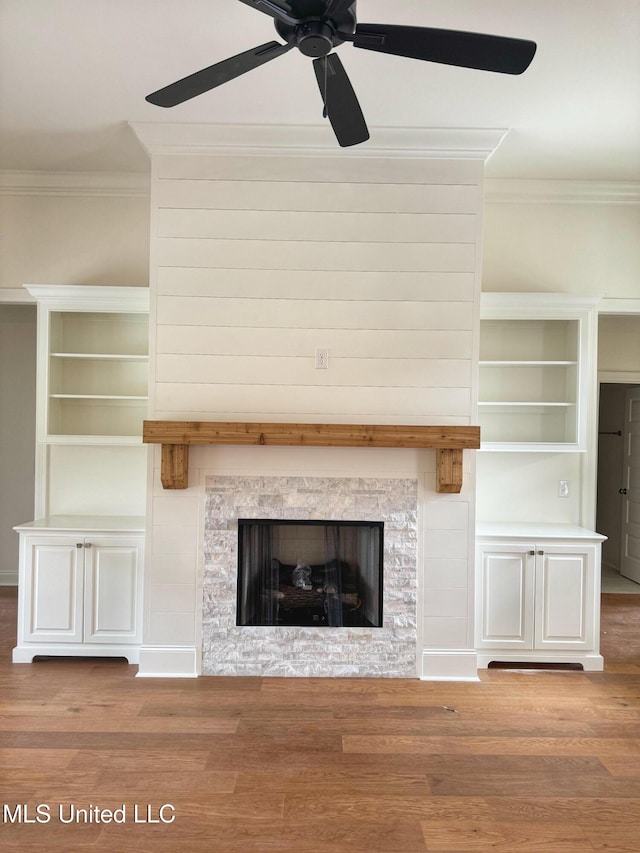 unfurnished living room featuring a stone fireplace, ceiling fan, light wood-type flooring, and ornamental molding