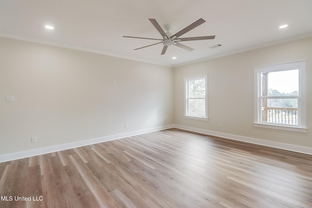 spare room featuring baseboards, visible vents, crown molding, and light wood finished floors