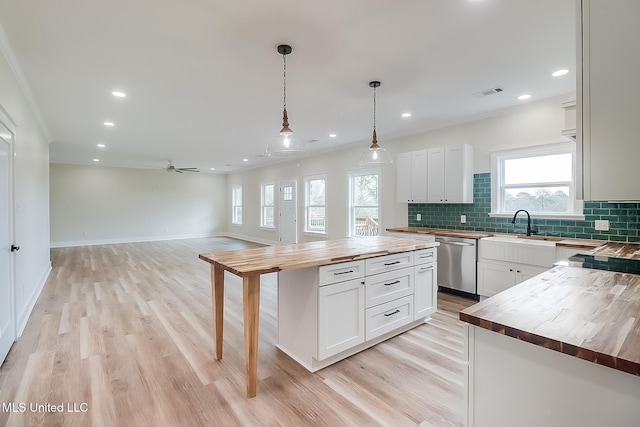 kitchen with a center island, white cabinetry, wooden counters, decorative backsplash, and dishwasher