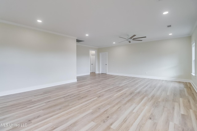 spare room featuring light wood finished floors, visible vents, and crown molding