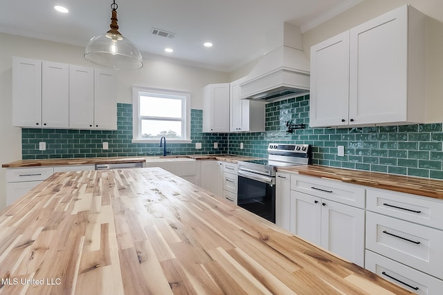 kitchen with butcher block counters, stainless steel appliances, and decorative light fixtures