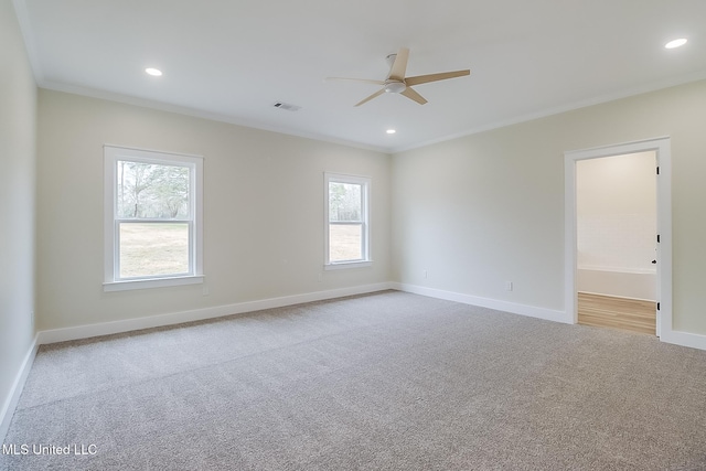 empty room with light carpet, baseboards, visible vents, and ornamental molding