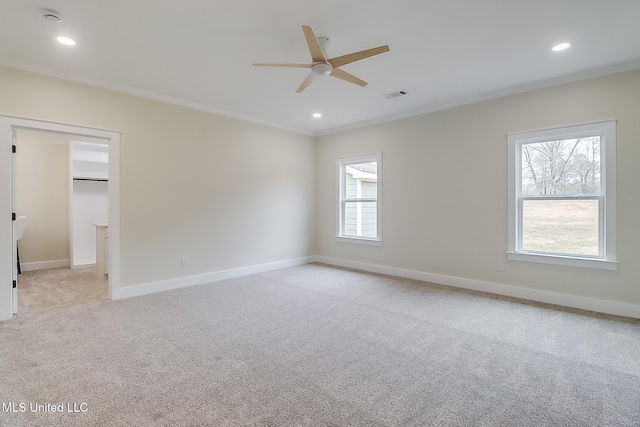 unfurnished room featuring visible vents, light colored carpet, and ornamental molding