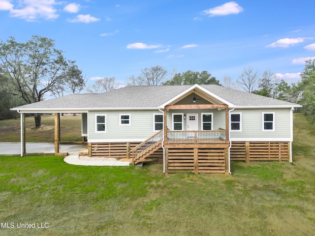 rear view of property featuring a yard, stairway, a carport, and roof with shingles