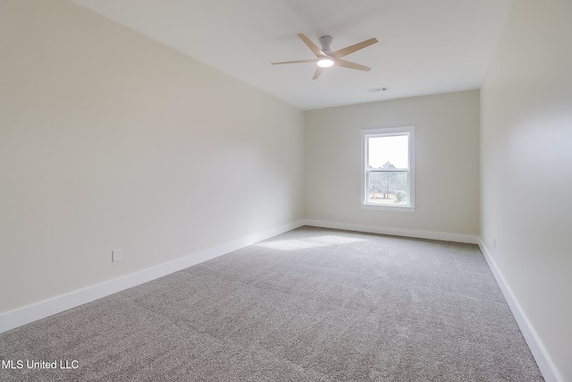 carpeted empty room featuring ceiling fan and baseboards