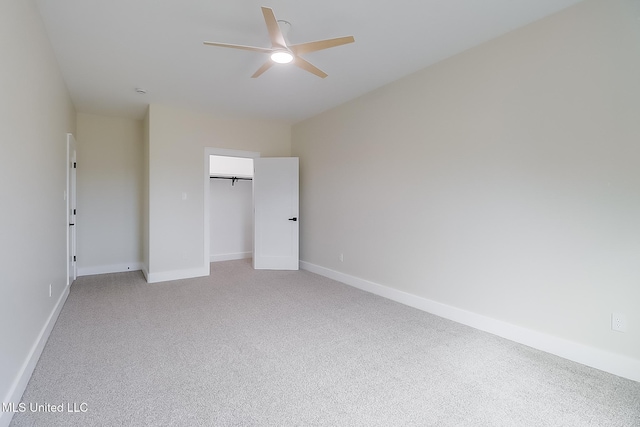 unfurnished bedroom with light carpet, ceiling fan, a closet, and baseboards