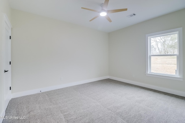 empty room featuring ceiling fan, carpet, visible vents, and baseboards