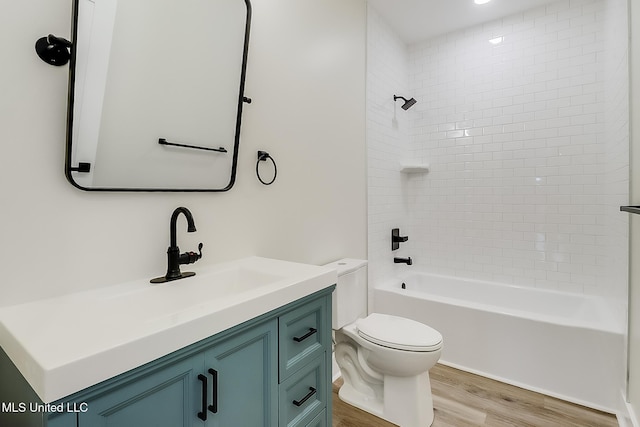 bathroom with washtub / shower combination, vanity, toilet, and wood finished floors