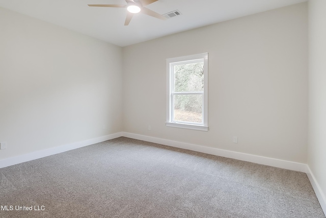 carpeted empty room with visible vents, ceiling fan, and baseboards