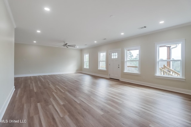 unfurnished living room featuring light wood finished floors, plenty of natural light, and visible vents