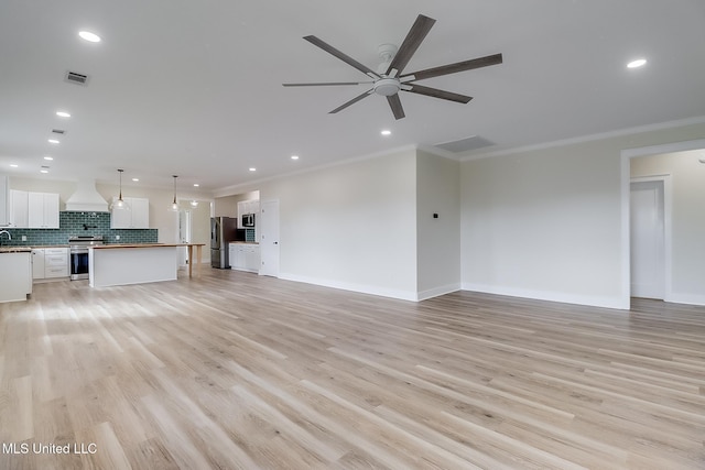 unfurnished living room with light wood-style flooring, recessed lighting, visible vents, and crown molding