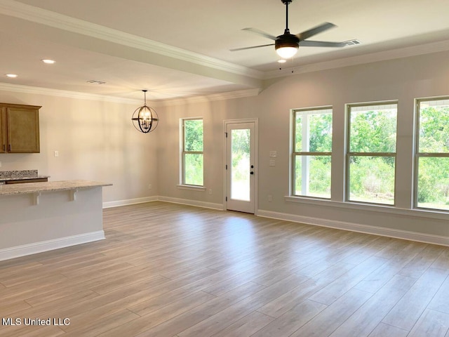 10241 Patrick Dr, Gulfport, MS 39503 - unfurnished living room with baseboards, light wood finished floors, plenty of natural light, and ceiling fan with notable chandelier