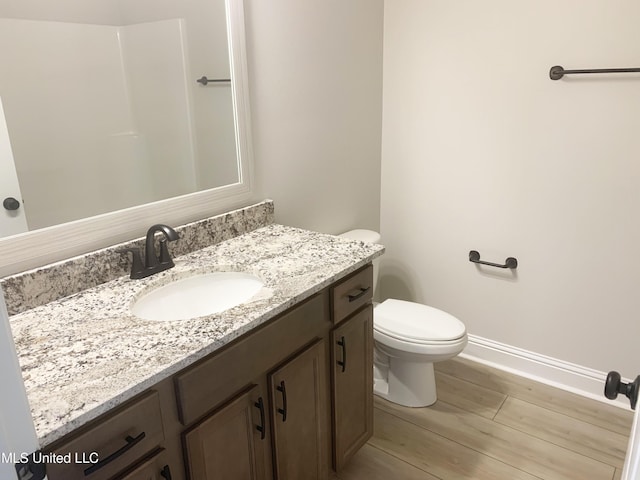 10241 Patrick Dr, Gulfport, MS 39503 - bathroom with toilet, baseboards, wood finished floors, and vanity
