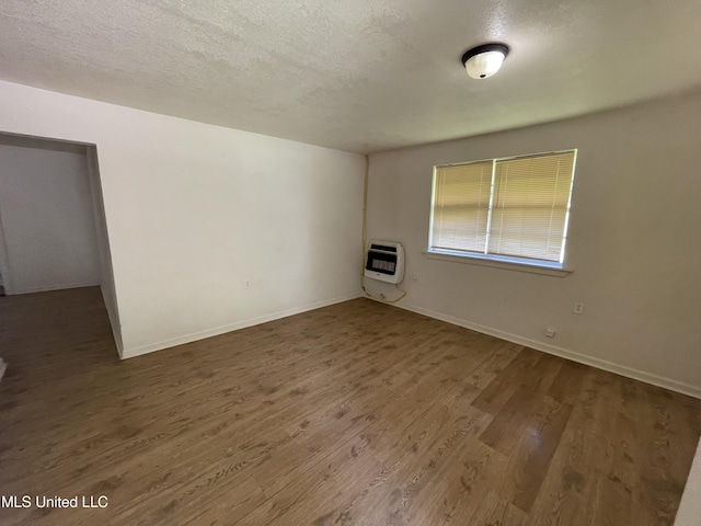 3701 14th St, Gulfport, MS 39501 - empty room with heating unit, wood finished floors, baseboards, and a textured ceiling