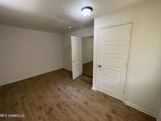 3701 14th St, Gulfport, MS 39501 - unfurnished bedroom with wood finished floors, baseboards, and a textured ceiling