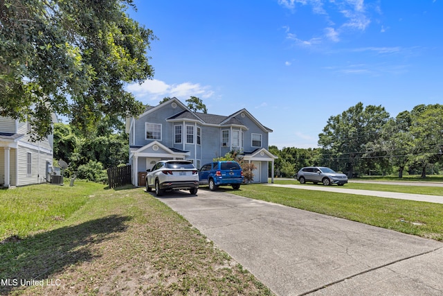 view of front of home with cooling unit, a garage, and a front yard