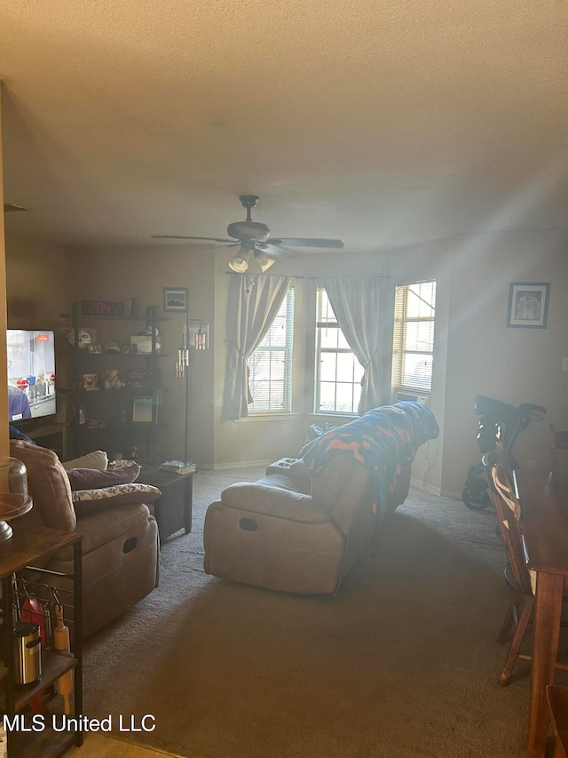 carpeted living room with a textured ceiling and ceiling fan