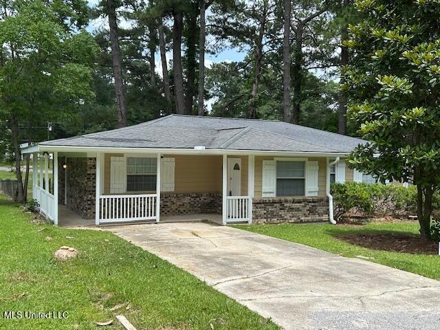 805 Choctaw Dr, Laurel, MS 39440 - view of front facade with covered porch, a front lawn, brick siding, and a shingled roof