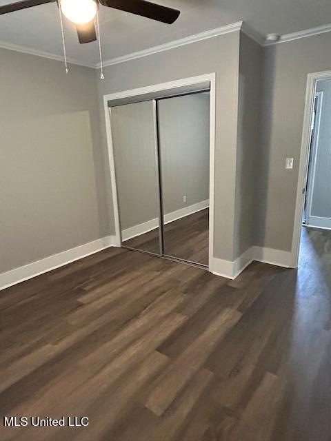 805 Choctaw Dr, Laurel, MS 39440 - unfurnished bedroom featuring crown molding, dark wood finished floors, baseboards, a closet, and ceiling fan