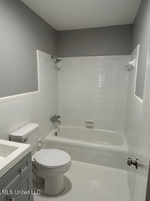 805 Choctaw Dr, Laurel, MS 39440 - bathroom featuring tile walls,  shower combination, toilet, vanity, and tile patterned flooring