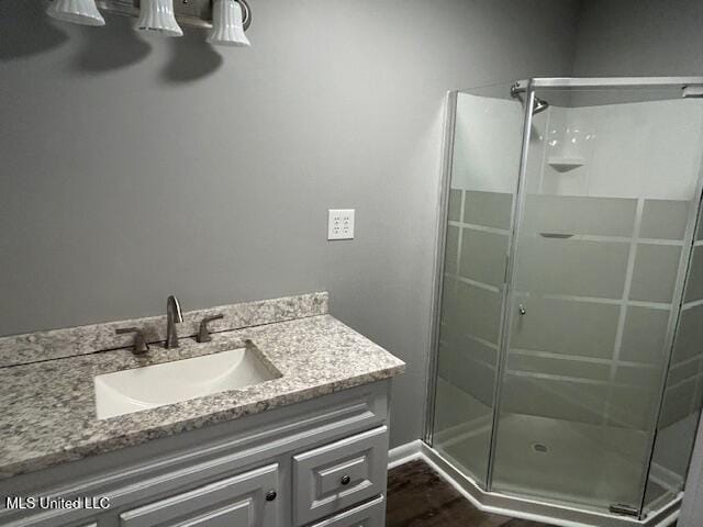805 Choctaw Dr, Laurel, MS 39440 - full bathroom with a stall shower, vanity, and wood finished floors