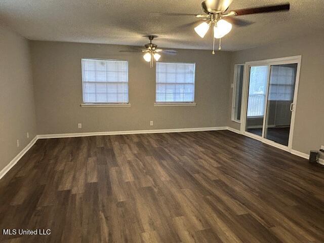 805 Choctaw Dr, Laurel, MS 39440 - unfurnished room with a textured ceiling, dark wood-type flooring, baseboards, and ceiling fan
