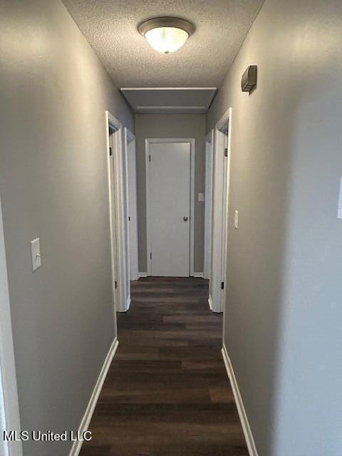 805 Choctaw Dr, Laurel, MS 39440 - hallway with a textured ceiling, dark wood-type flooring, and baseboards