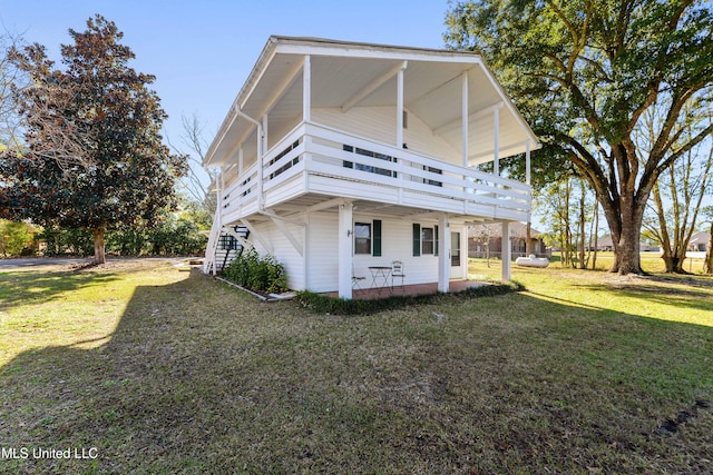 rear view of property featuring a lawn