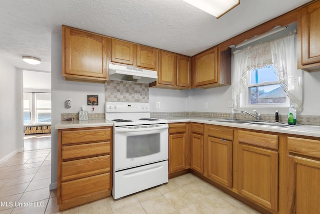 kitchen with a healthy amount of sunlight, sink, white electric range oven, and a textured ceiling