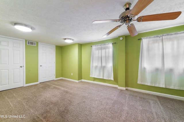 spare room featuring ceiling fan, carpet floors, and a textured ceiling