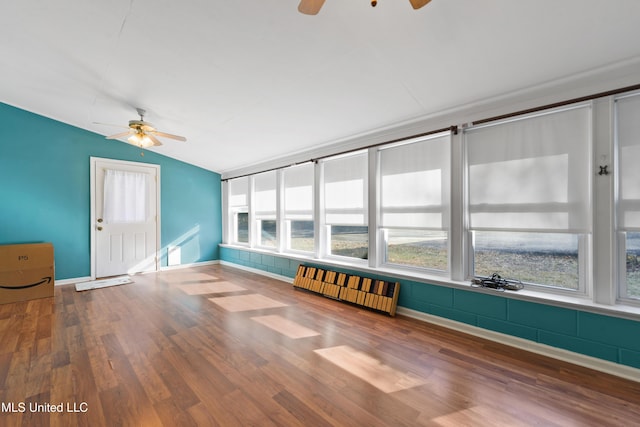 unfurnished sunroom featuring lofted ceiling, ceiling fan, and radiator heating unit