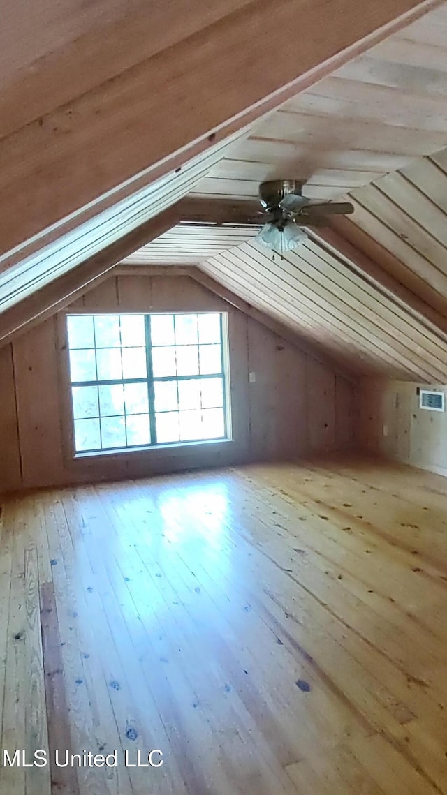 additional living space featuring vaulted ceiling, hardwood / wood-style flooring, and ceiling fan