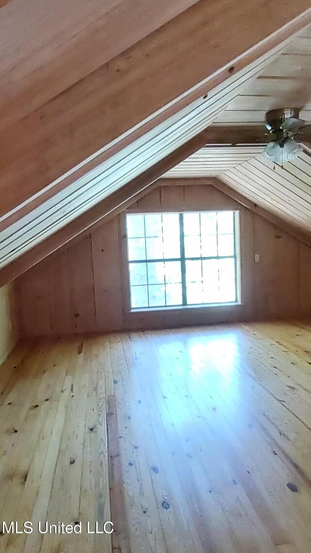 bonus room featuring vaulted ceiling, light wood-type flooring, a healthy amount of sunlight, and ceiling fan