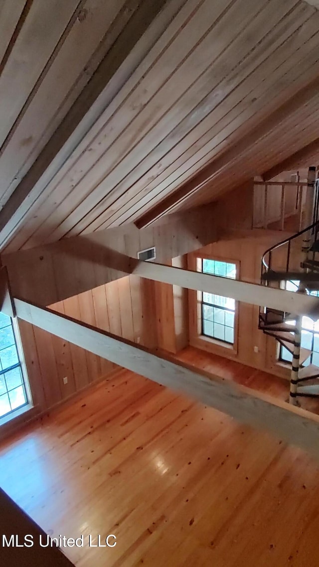additional living space featuring lofted ceiling, wood finished floors, and wood walls