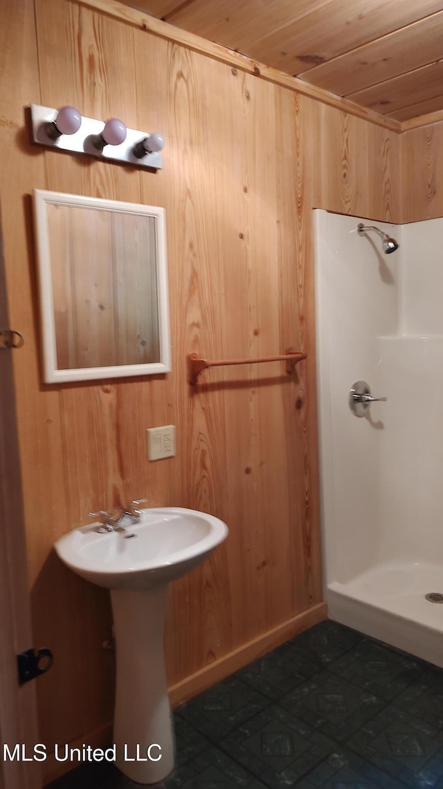 full bath with a shower stall, wood ceiling, and wooden walls