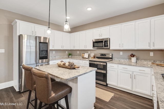 kitchen with stainless steel appliances, dark wood finished floors, a kitchen island, and white cabinetry