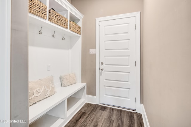 mudroom with dark wood finished floors and baseboards