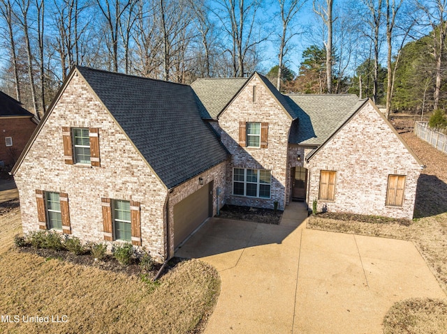 view of front facade featuring driveway, brick siding, roof with shingles, and an attached garage