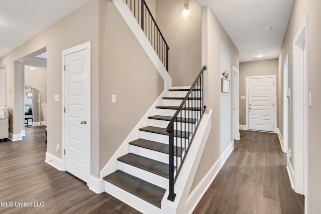 stairway featuring baseboards and wood finished floors