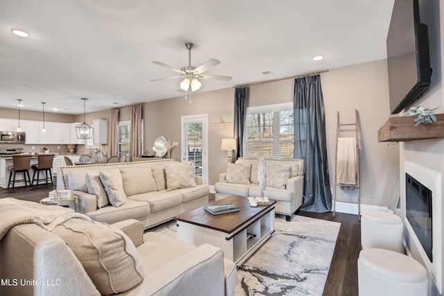 living area with ceiling fan, recessed lighting, dark wood finished floors, and a glass covered fireplace