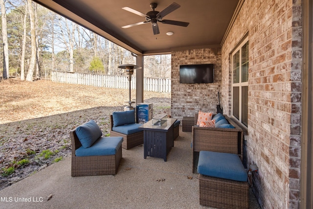 view of patio featuring a ceiling fan, outdoor lounge area, and fence