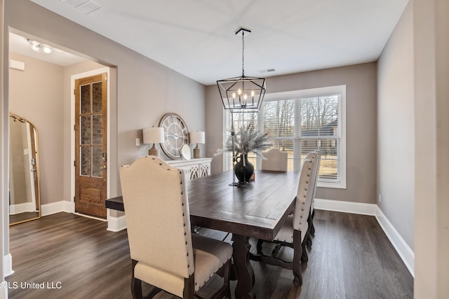 dining room featuring baseboards, visible vents, a chandelier, and dark wood-style flooring